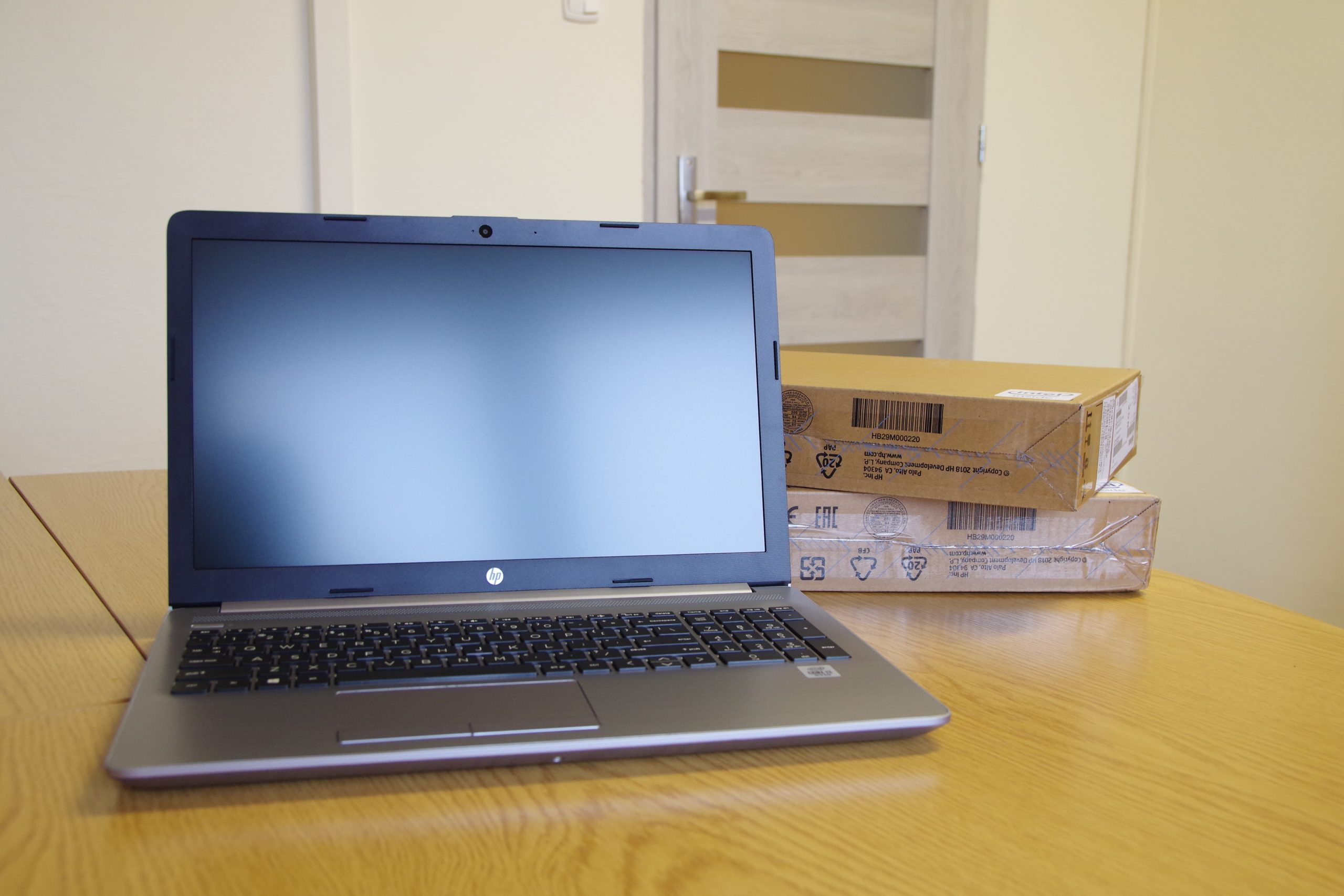 Obrazek przedstawia jeden z zakupionych laptopów z otwartym ekranem ustawiony na biurku.
