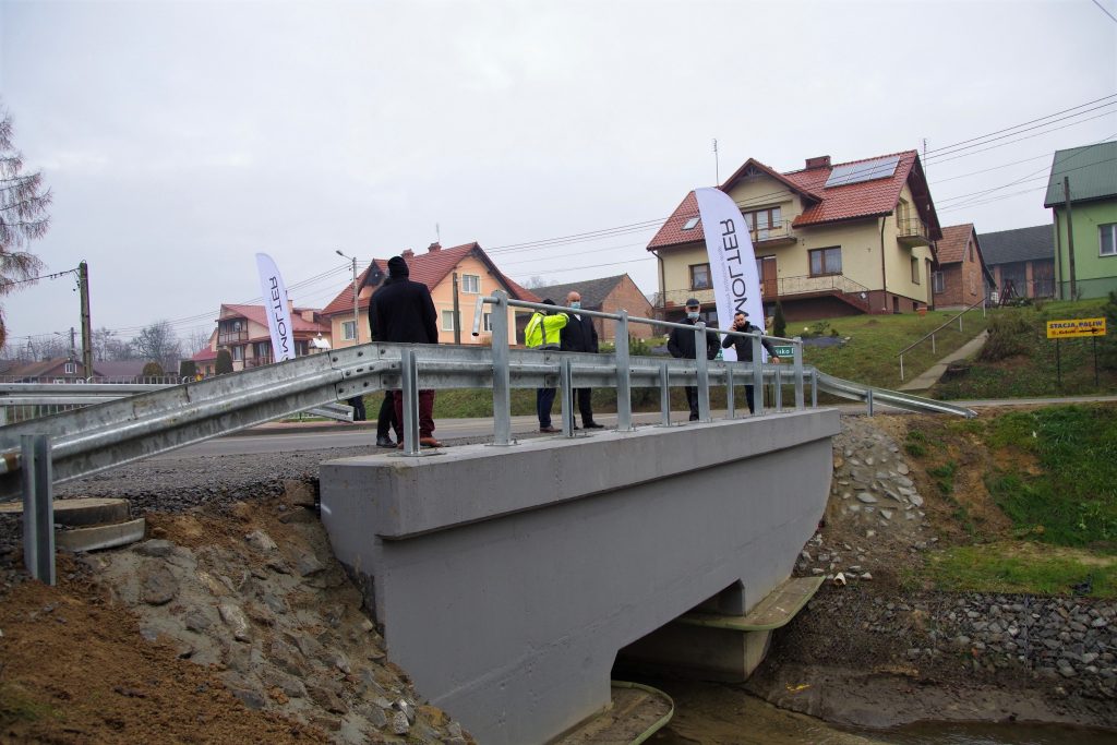 Jeden z mostków wyremontowanych w ramach przebudowy drogi. Na nim stoją wykonawcy oraz inwestorzy przebudowy drogi podczas jej odbioru.