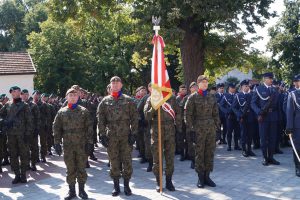 Kompania honorowa oddziału saperów stojąca w szyku na placu przed sanktuarium przodem do ołtarza.. Jeden z żołnierzy trzyma sztandar oddziału.